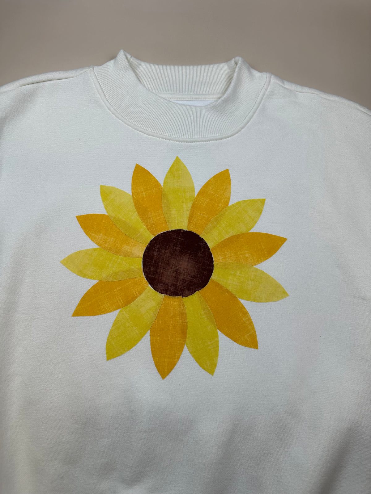 White T-shirt with yellow sunflower applique patch on the chest