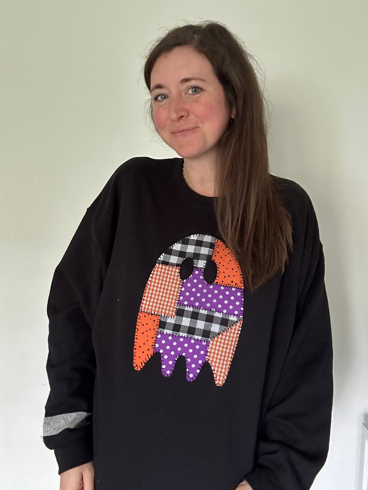 Black crewneck sweatshirt with patchwork applique ghost graphic