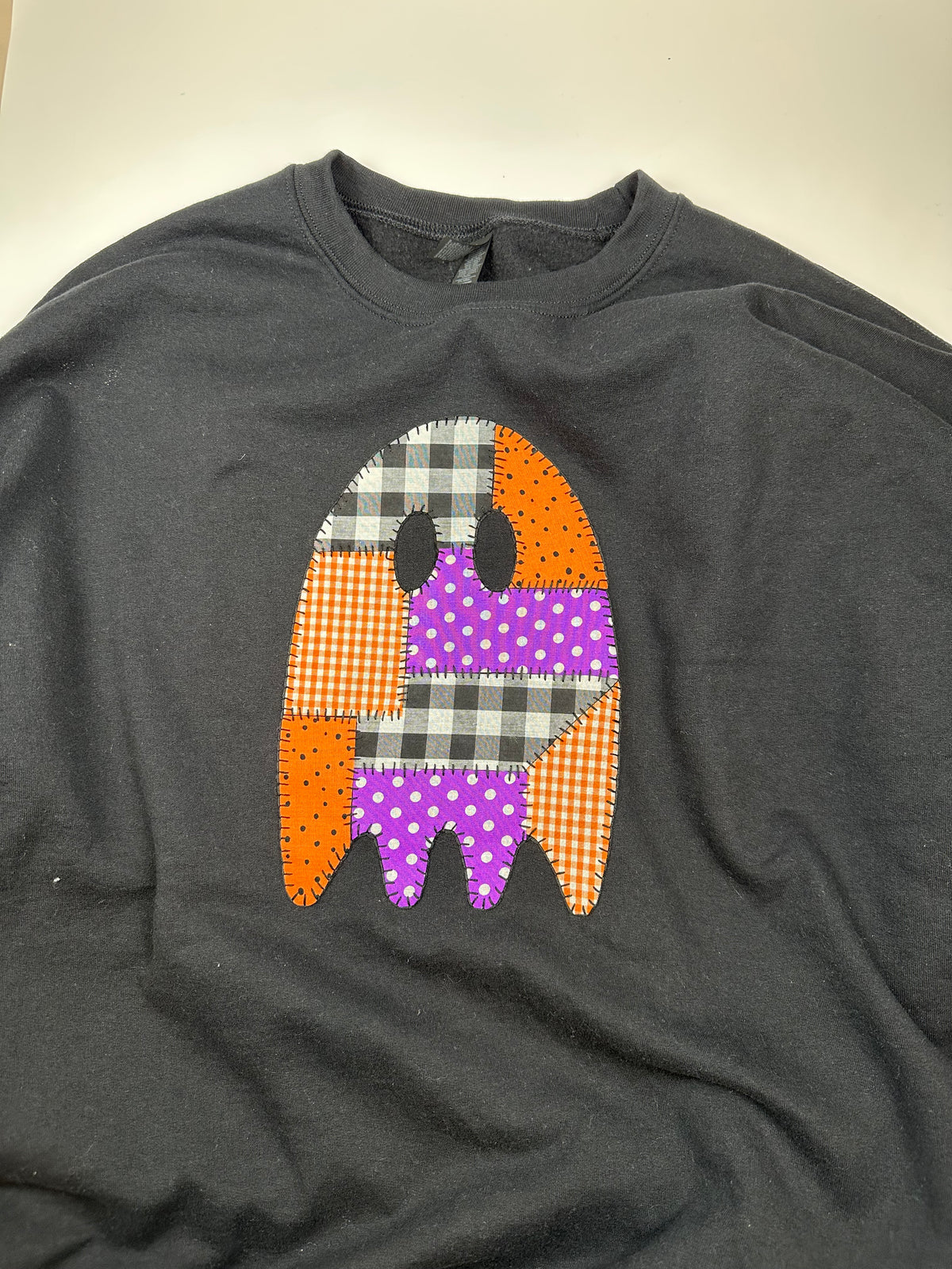Dark gray crewneck sweatshirt with patchwork applique ghost graphic