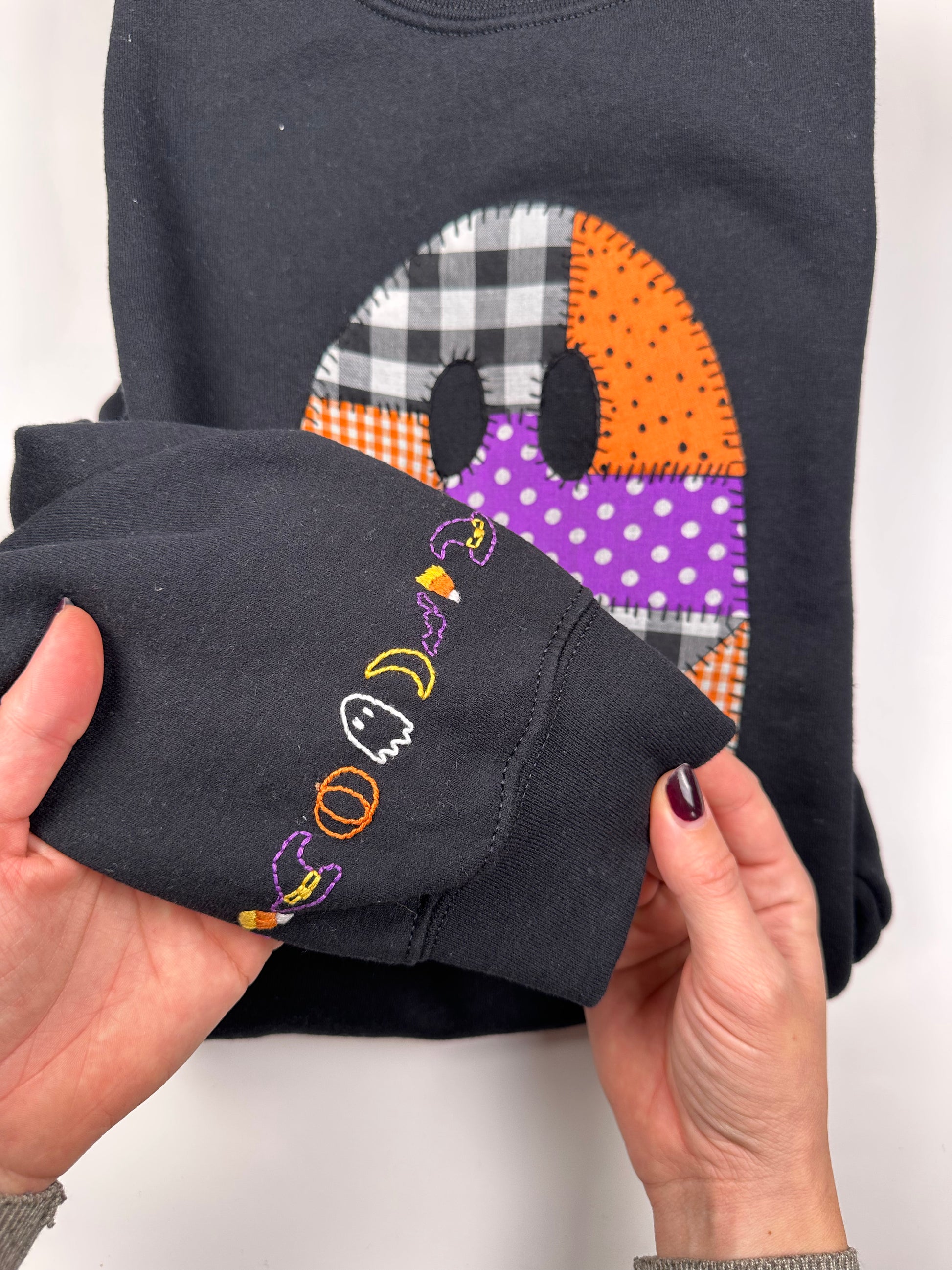 Dark hoodie sleeve cuff with colorful "boo" embroidery