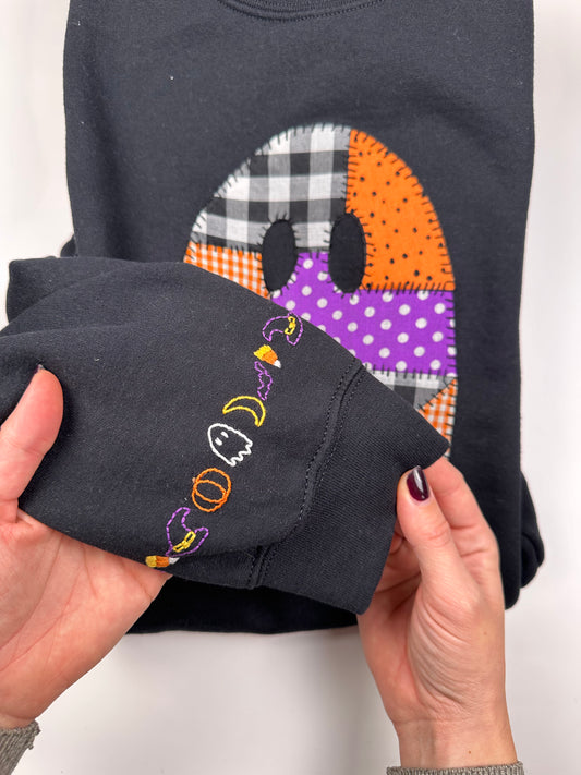 Dark hoodie sleeve cuff with colorful "boo" embroidery